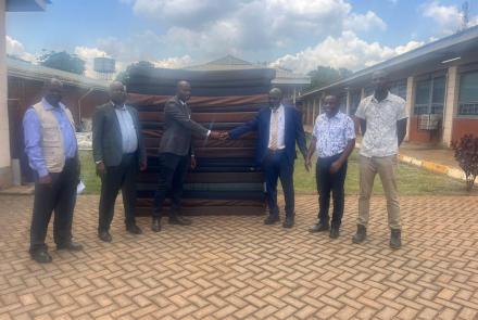 :(center), the Kayunga RRH Board Chairperson Dr. Mpooya Simon handing over 20 mattresses to Hajji Isa Mbooge(yellow neck tie) the Buvuma CAO int the presence of Hajji Salim Kivejinja-Hospital Administrator (2nd left) and Buvuma HCIV Incharge (2nd right)